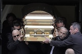 Pallbearers carry Carl Williams' golden casket from the church after his funeral on April 30, 2010.