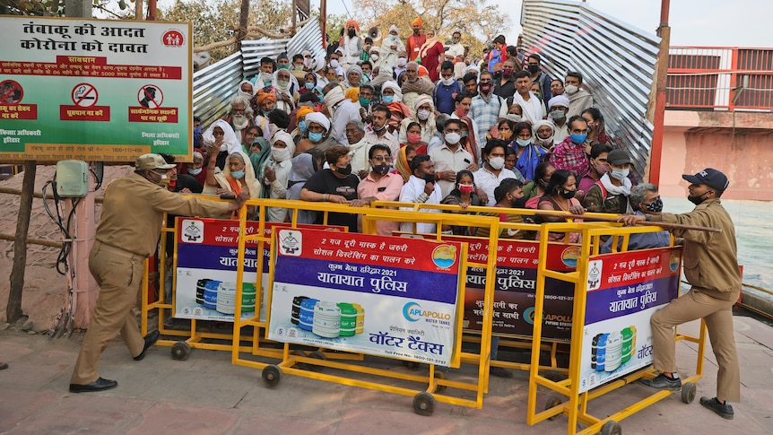 Crowds of worshippers stand behind barricades