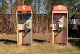Image of two old phone boxes at a road house in northern Western Australia.