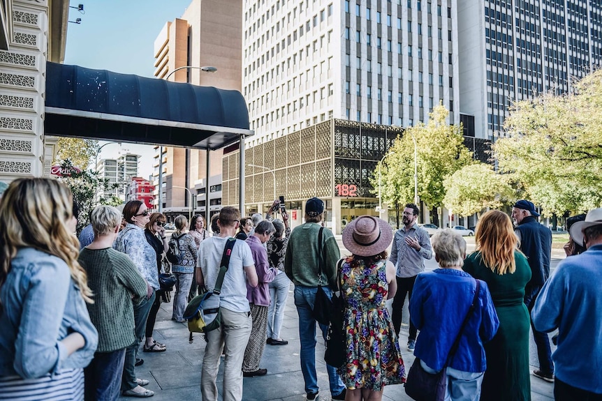 People on a tour in front of office buildings