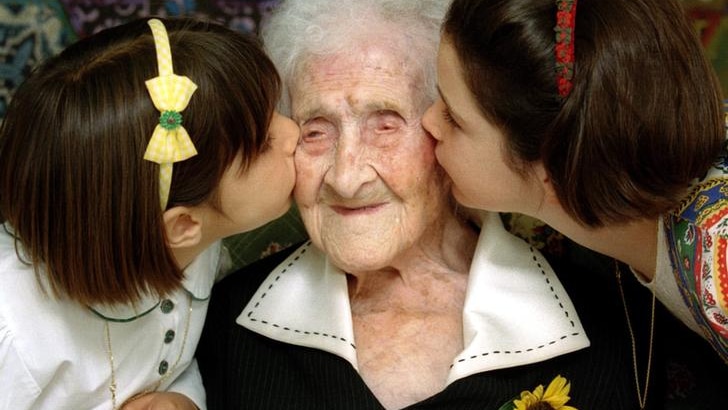 Jeanne Calment is kissed by two young girls in Arles.