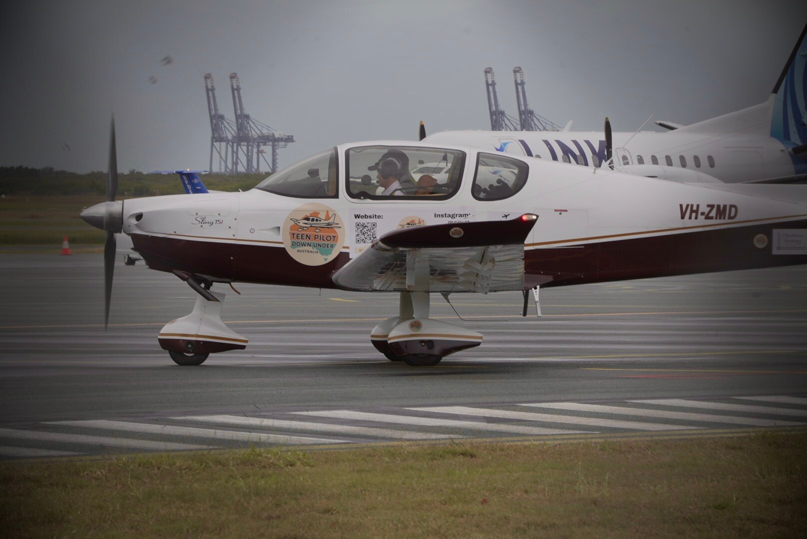 A small plane on a tarmac with pilots inside 