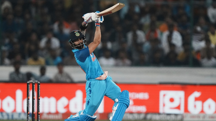 Indian cricketer Virat Kohli extends his bat in a follow-through after hitting the ball down the ground in a T20 International.
