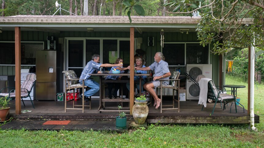 Four people cheers under a house