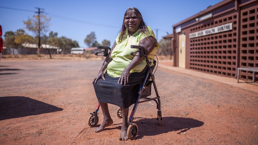 A woman sits outside the dialysis clinic in Docker River, NT.