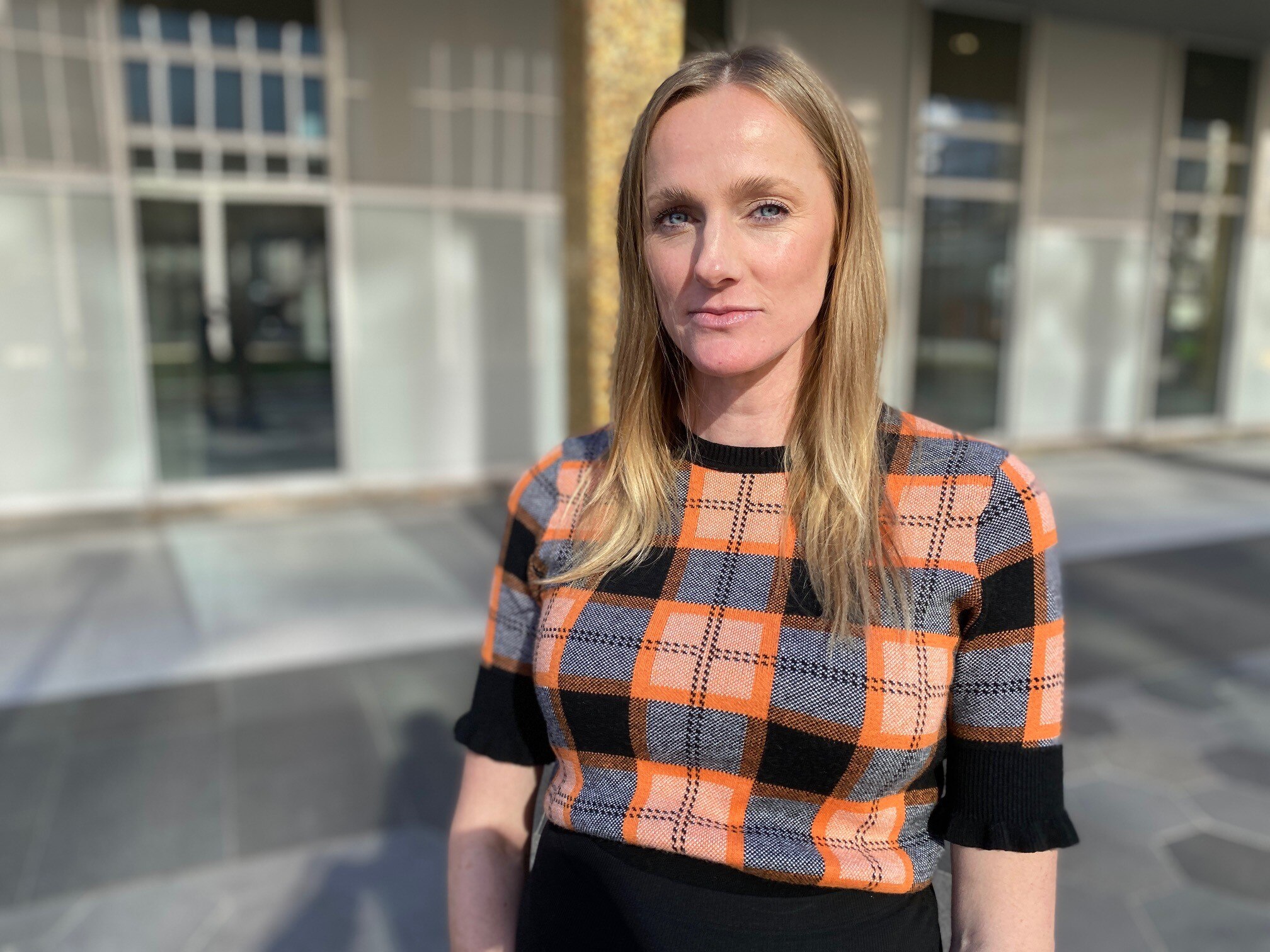 A blonde woman with a tartan jumper. 