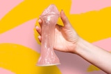 Close up image of hand holding up a female condom