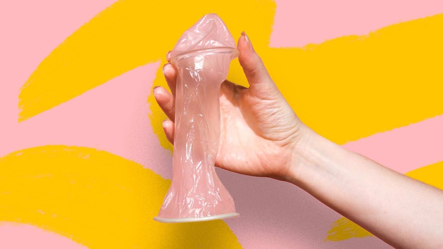 Close up image of hand holding up a female condom