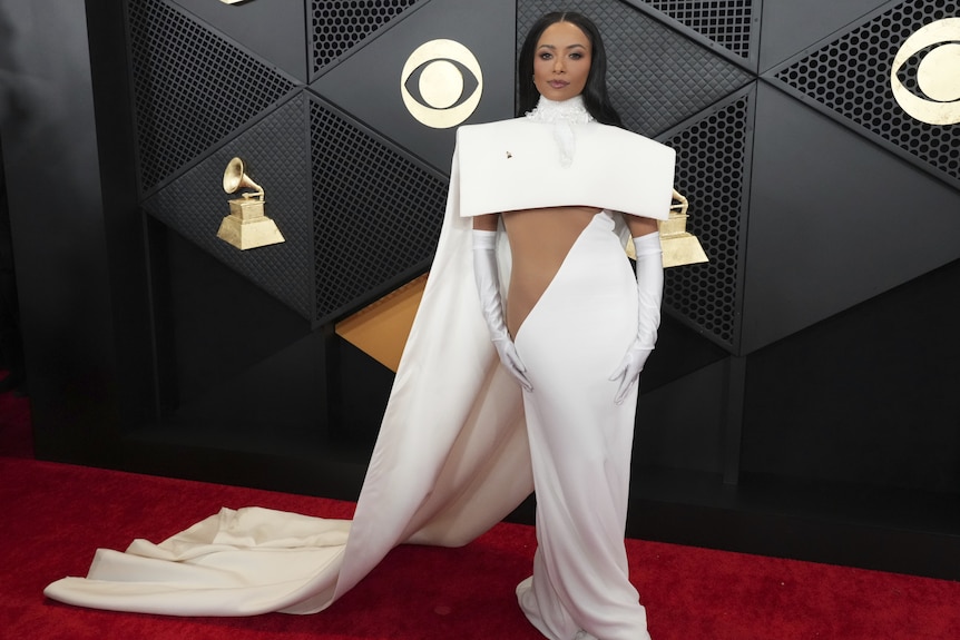 Kat Graham wearing a dress with a long white cape, a deep side cutout and long gloves
