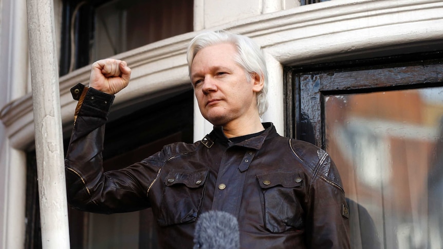 Julian Assange greets supporters outside the Ecuadorian embassy in London.