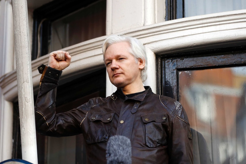 Julian Assange greets supporters outside the Ecuadorian embassy in London.