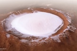 A vast crater in red dirt filled with white ice