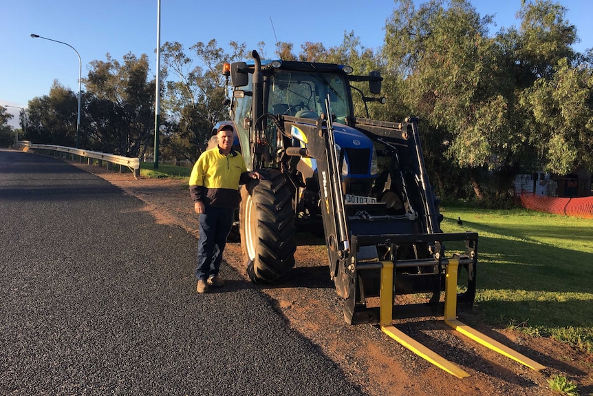 Farmer James Gibson with his tractor, which he was forced to drive into town due to flooding.