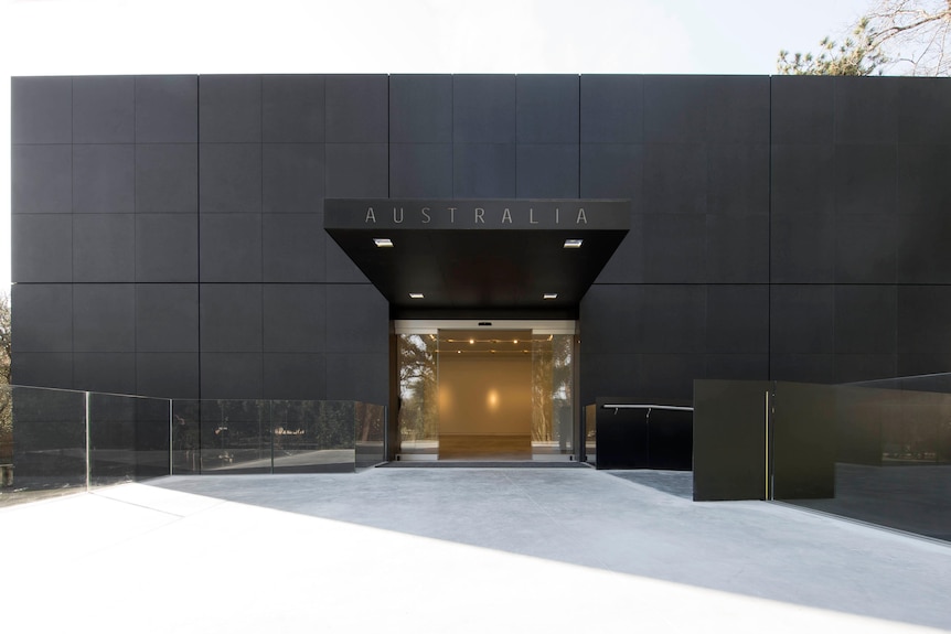 A black cube-like building with a glass entrance, above which reads "Australia".