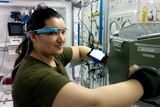A woman wearing a high tech head band at work in a laboratory.