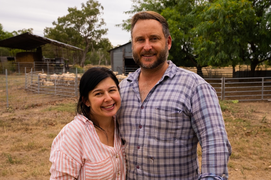 Photo of a man and a woman in front of a shearing shed.