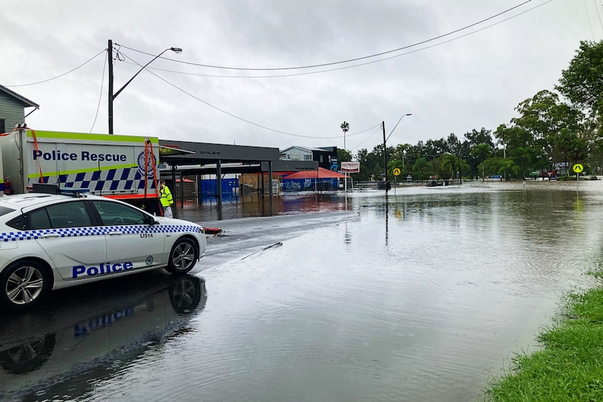 police cars on a road covered with floodwater
