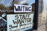 A sign saying 'staff wanter' in the window of a restaurant.