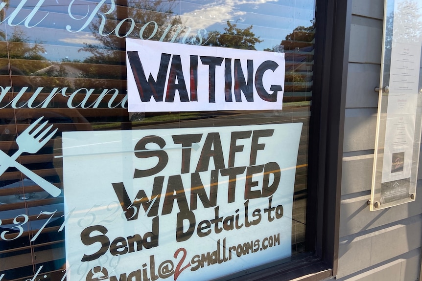 A sign saying 'staff wanter' in the window of a restaurant.