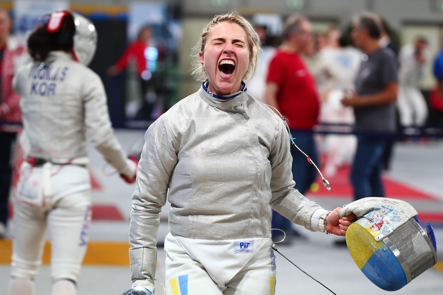 A woman screams with joy after a fencing battle.