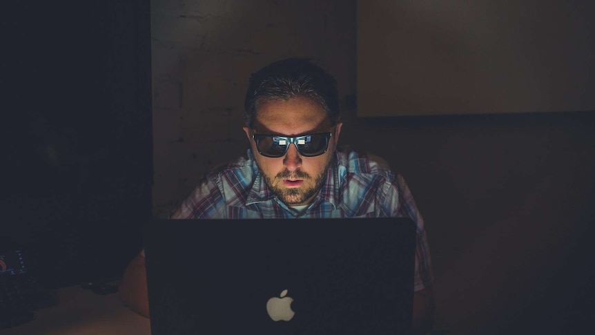 Man in the dark working on computer