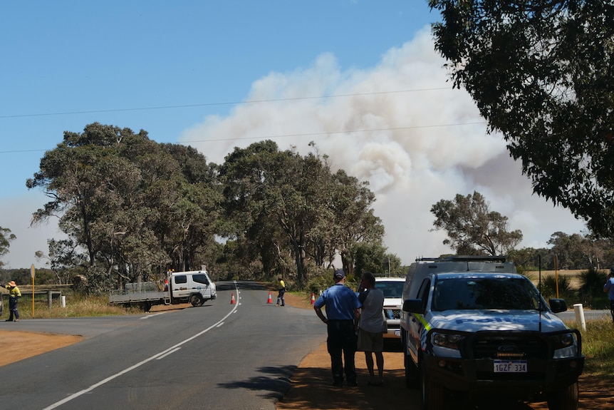 A roadblock with smoke seen in the distance