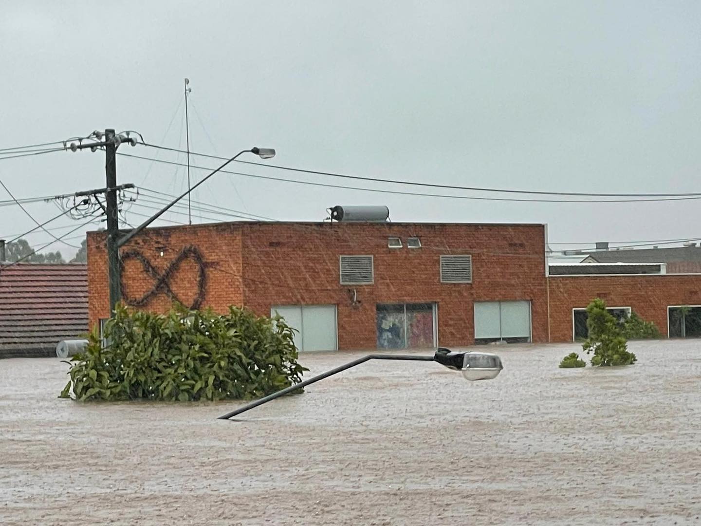 Un edificio de ladrillo rodeado por las inundaciones hasta las ventanas del segundo piso.