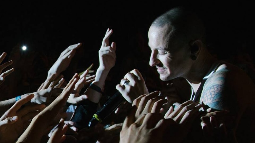 A shot of Chester Bennington reaching out to a crowd
