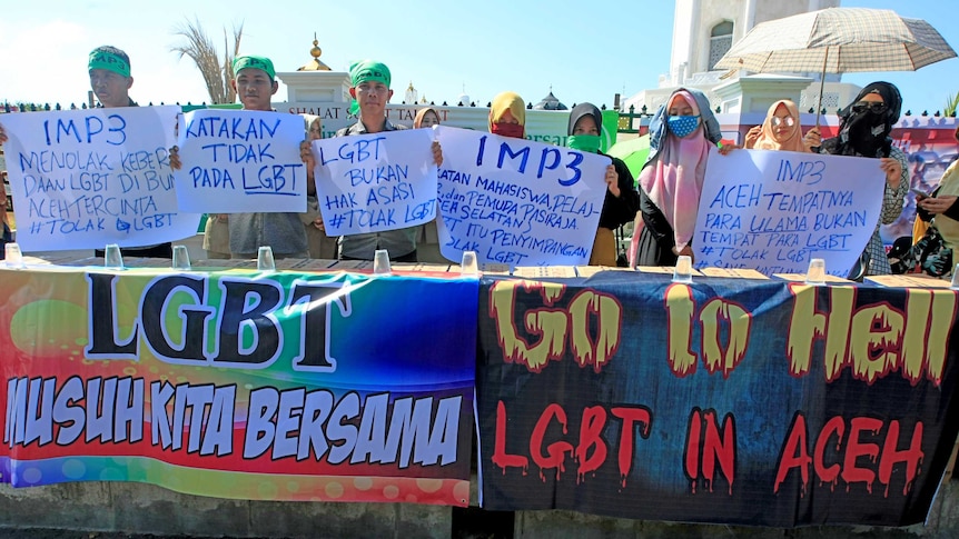 Sekelompok orang membawa spanduk dan tulisan anti LGBT