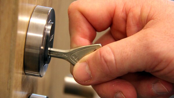 A key is placed in the lock of a door.