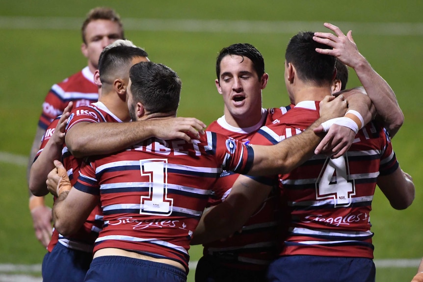 Sydney Roosters players celebrate an NRL try against the St George Illawarra Dragons.