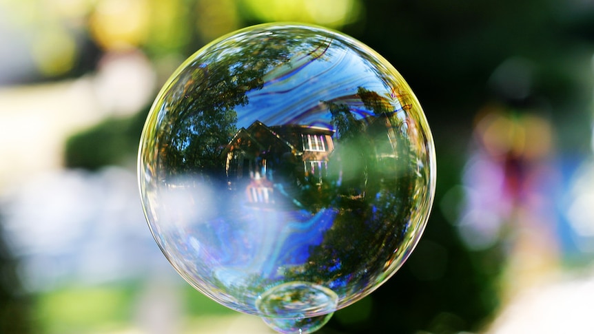 A house reflected in a giant soapy bubble.