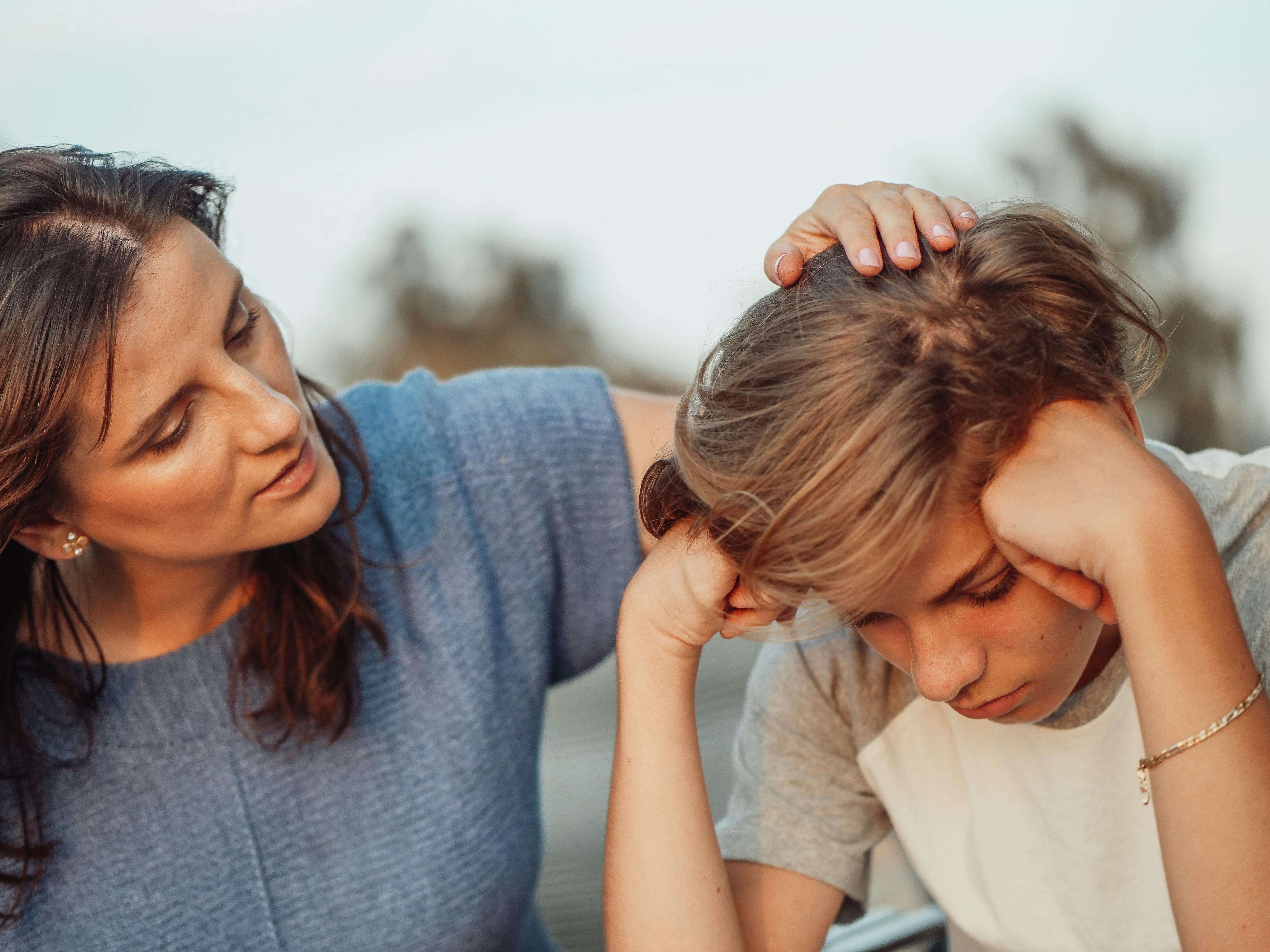 A woman comforting a young boy.