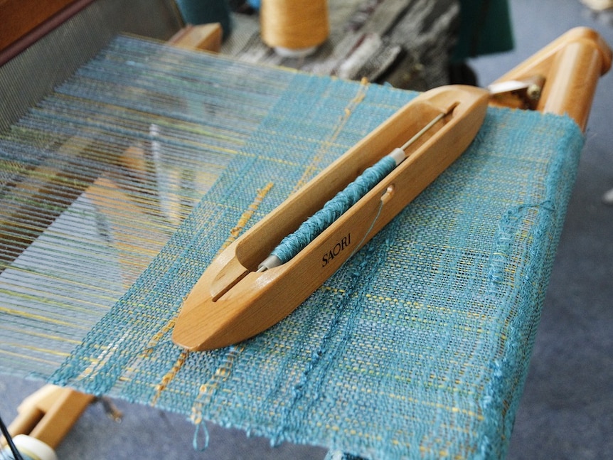 A Saori shuttle and weaving on a loom.