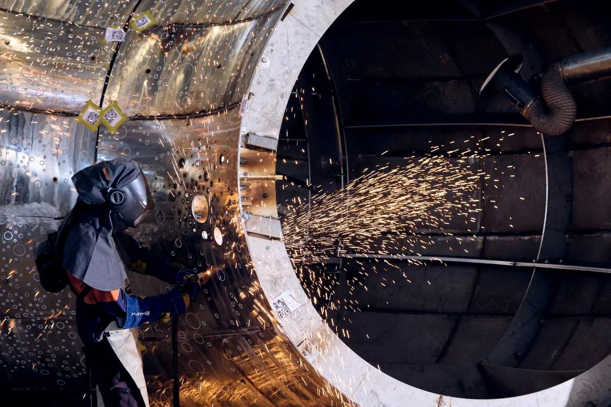A silver sculpture being welded in a foundry.