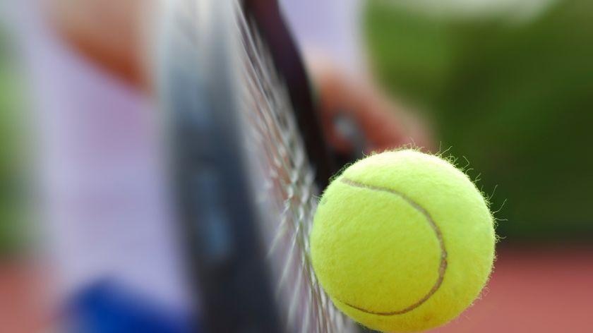 A tennis ball hits a racquet.