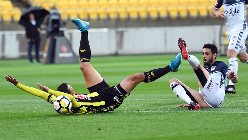 Andrija Kaludjerovic of the Phoenix falls after being tackled by Rhys Williams.