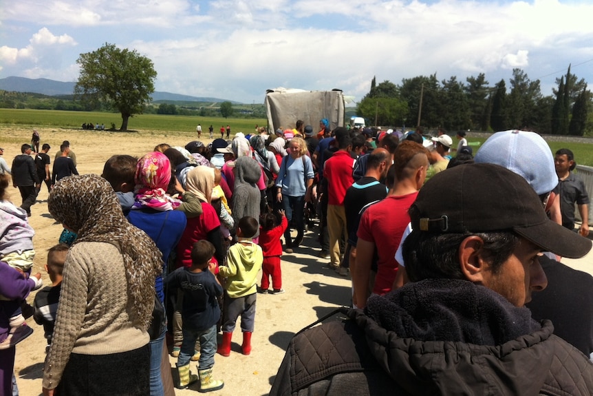 Two lines of asylum seekers wait for food at the Idomeni camp on the Greek border.