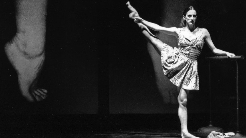 A black and white image of Meryl Tankard holding a ballet position.