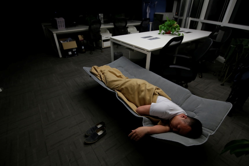 A man sleeping in bed in office