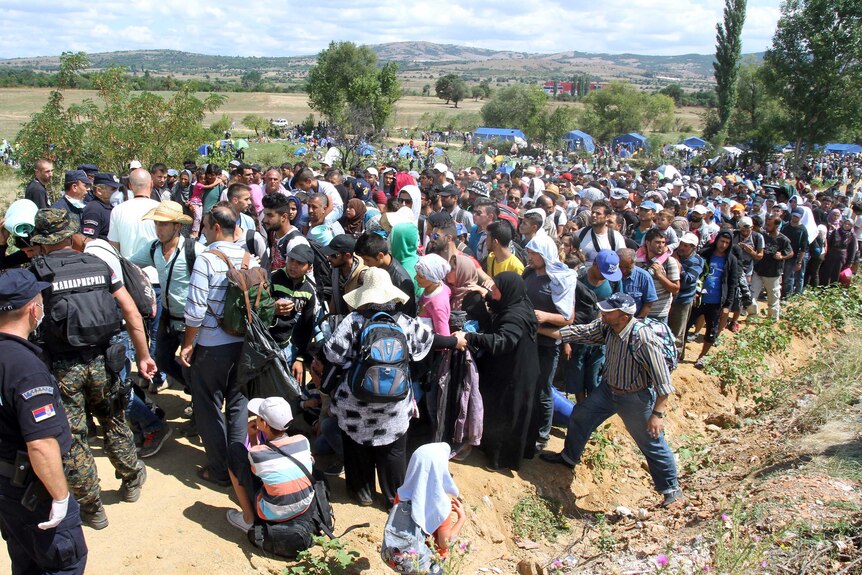 Migrants wait to enter a temporary centre in Serbia on the border with Macedonia.