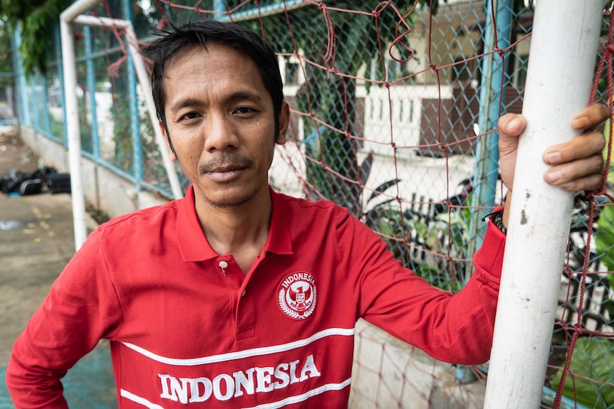 Akmal Marhali poses for the camera in a red Indonesia football jersey.