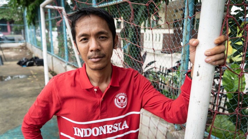 Akmal Marhali poses for the camera in a red Indonesia football jersey.