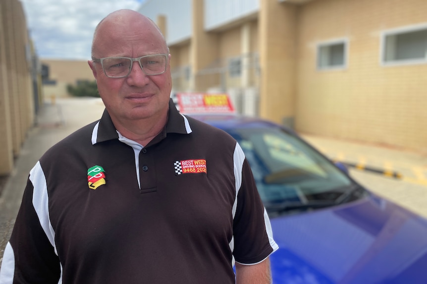 man standing in front of learning driver car in carpark