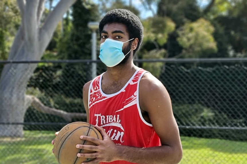 Buru in a mask holding a basketball