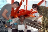 Lieutenant Alfonso Santos and medical officer Flight Lieutenant Jo Darby bandage asylum seeker