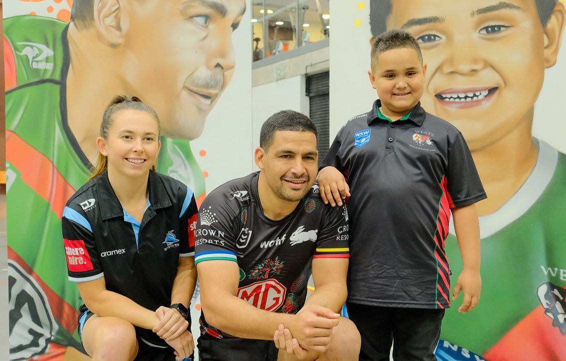 Cody Walker kneels as he poses for a photo with two kids at the National Center of Indigenous Excellence.