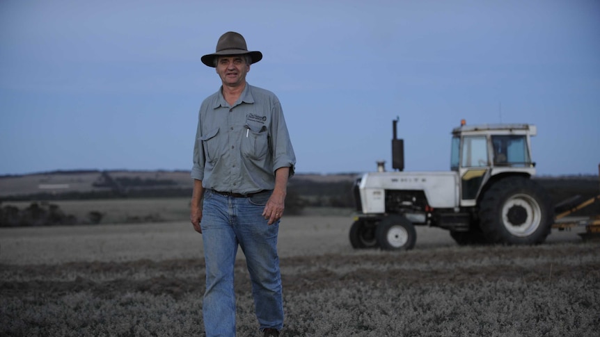 WA Landcare Network chair, Keith Bradby standing in a paddock with a tractor behind him