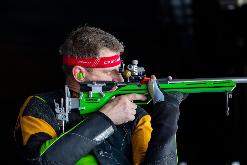close-up of a man lining up shot through a rifle sight