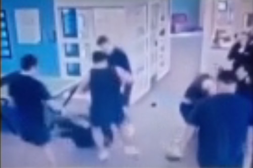 A blurry CCTV shot of unidentifed teens brawling.